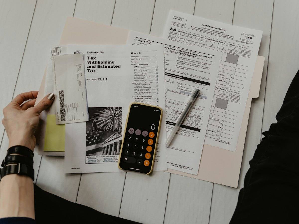 Financial documents, a calculator and a smartphone on a desk