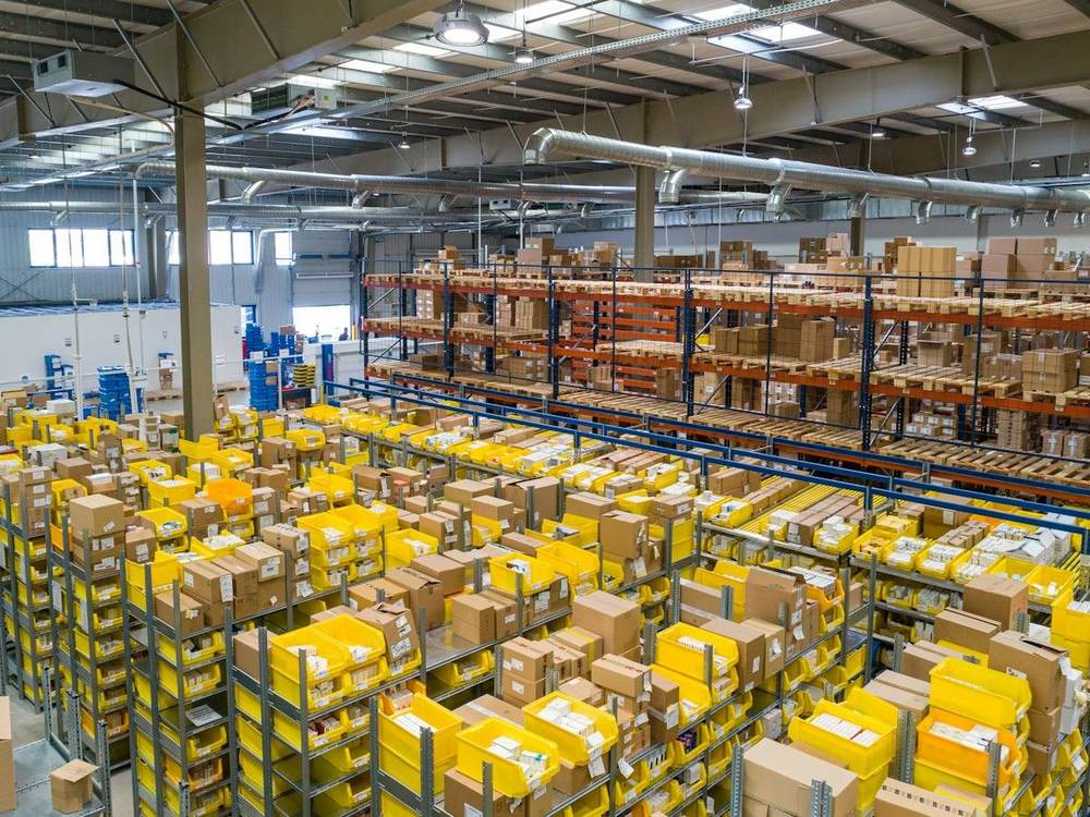 Warehouse aisles with high racking stacked with boxed inventory