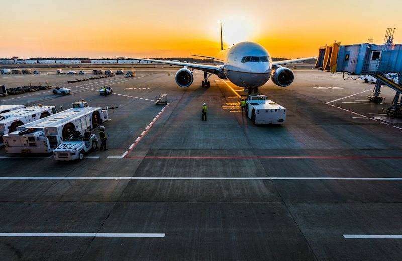 Passenger aircraft parked at an airport gate at sunset