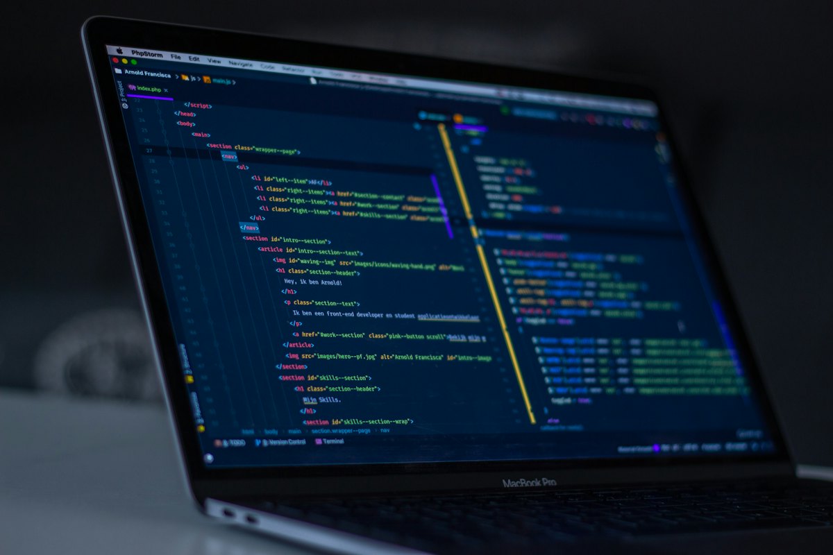 Laptop in a dark room with application source code open in an editor