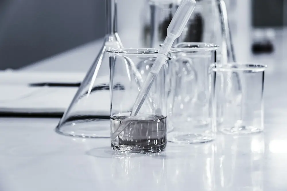 Glass beakers and a pipette on a white laboratory bench