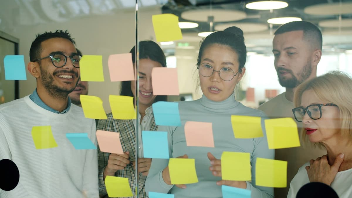A team planning together with sticky notes on a glass wall