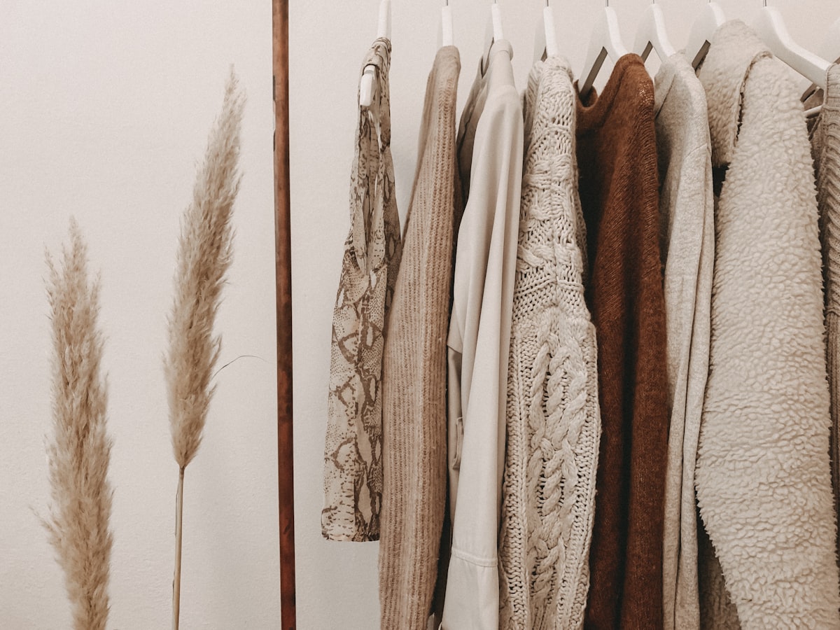 A curated rack of neutral-toned apparel in a boutique fitting room