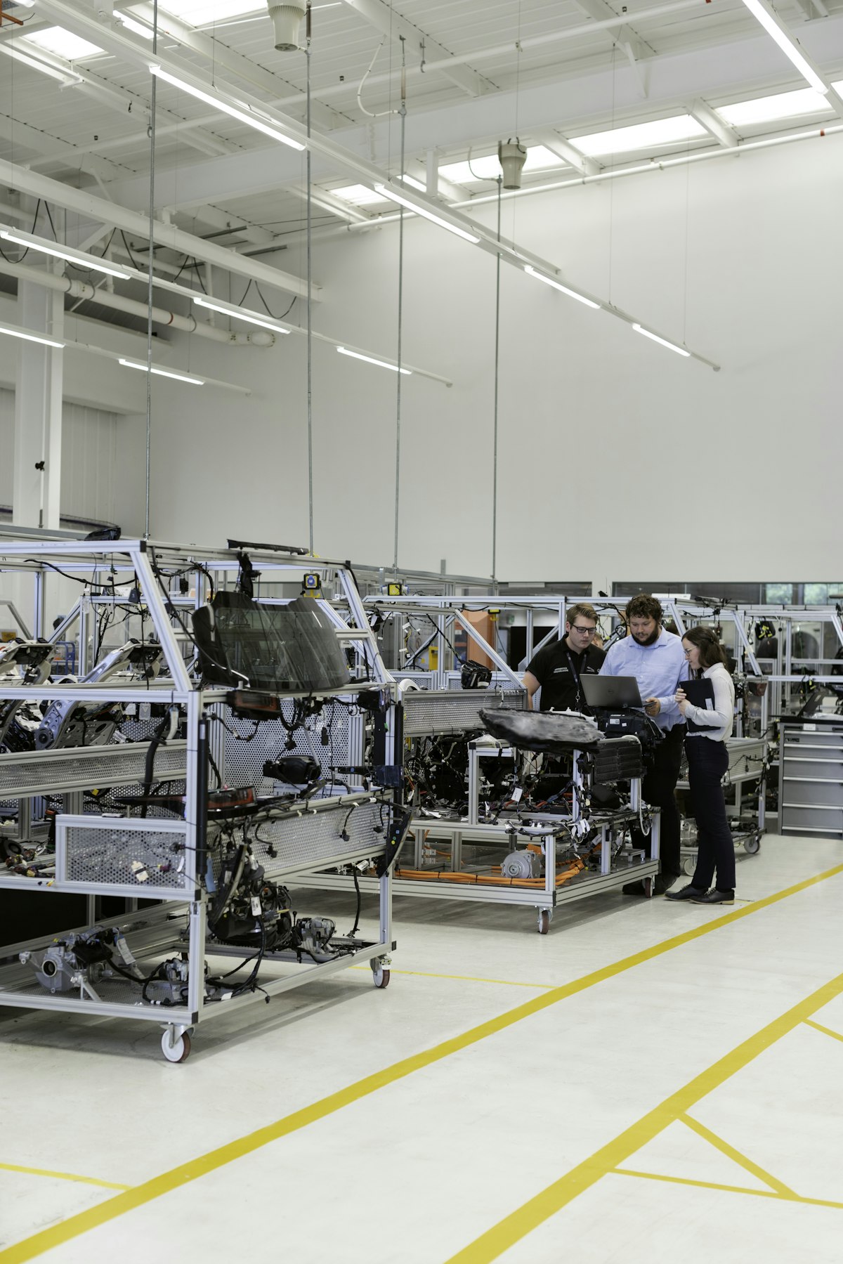 Automotive engineering team reviewing vehicle components on the production floor