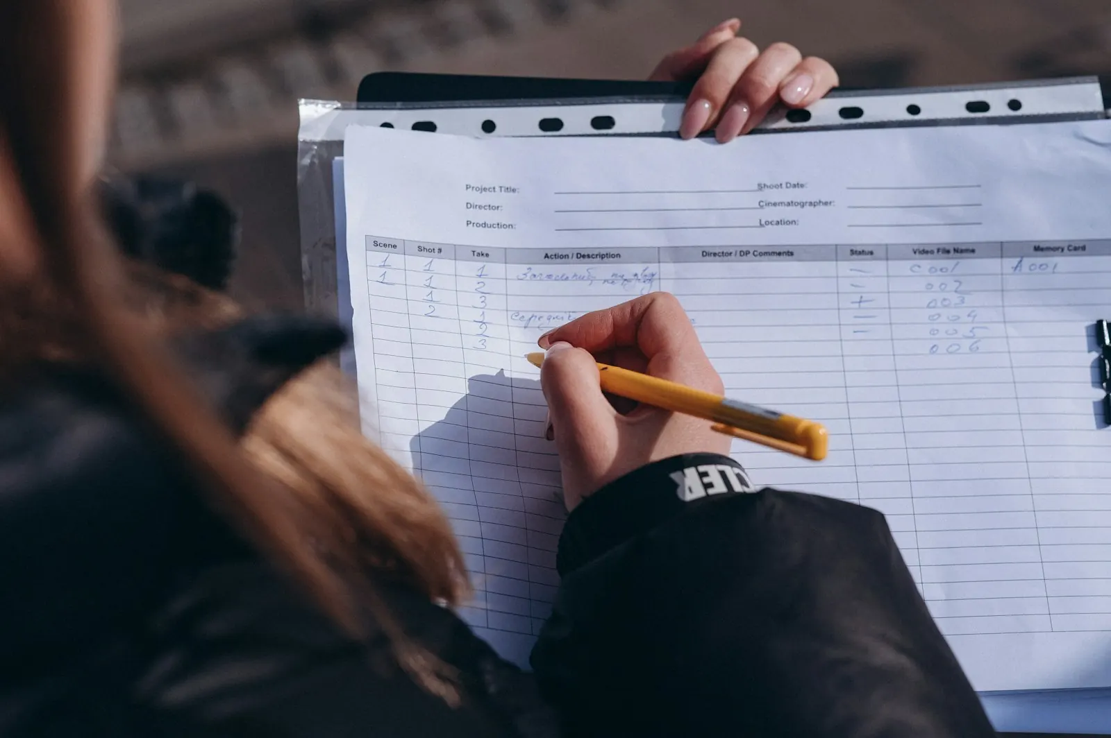 Hand filling in a paper production form with a pen