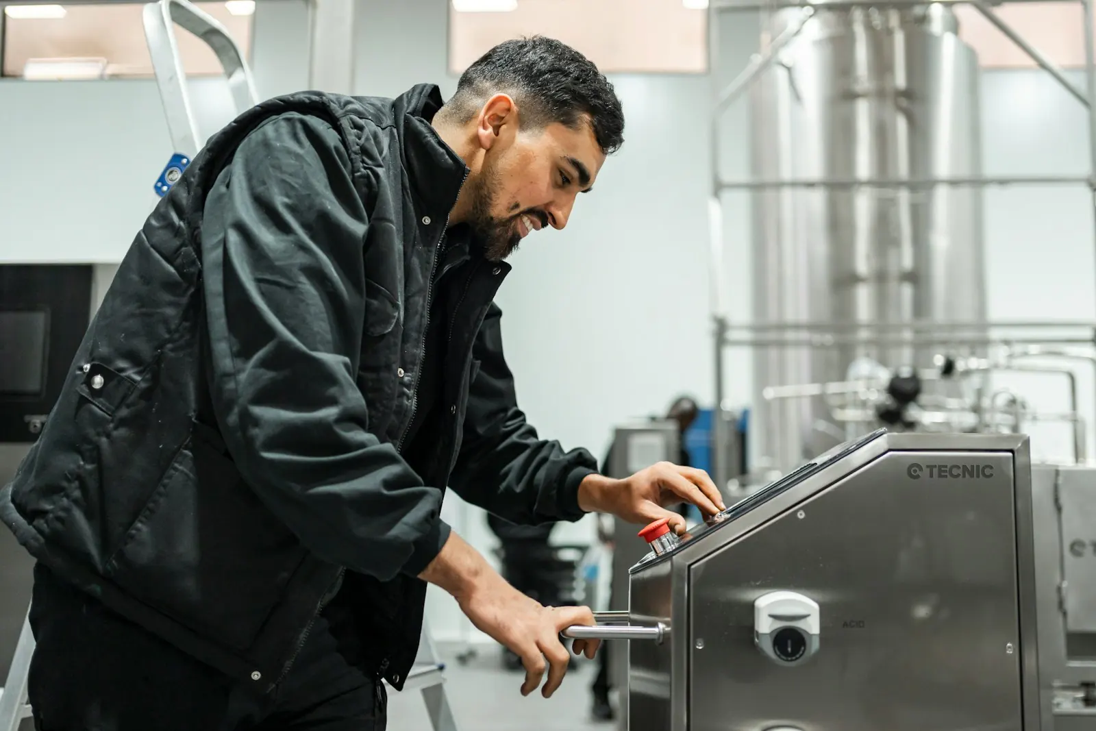 Operator using the control panel of stainless steel process equipment