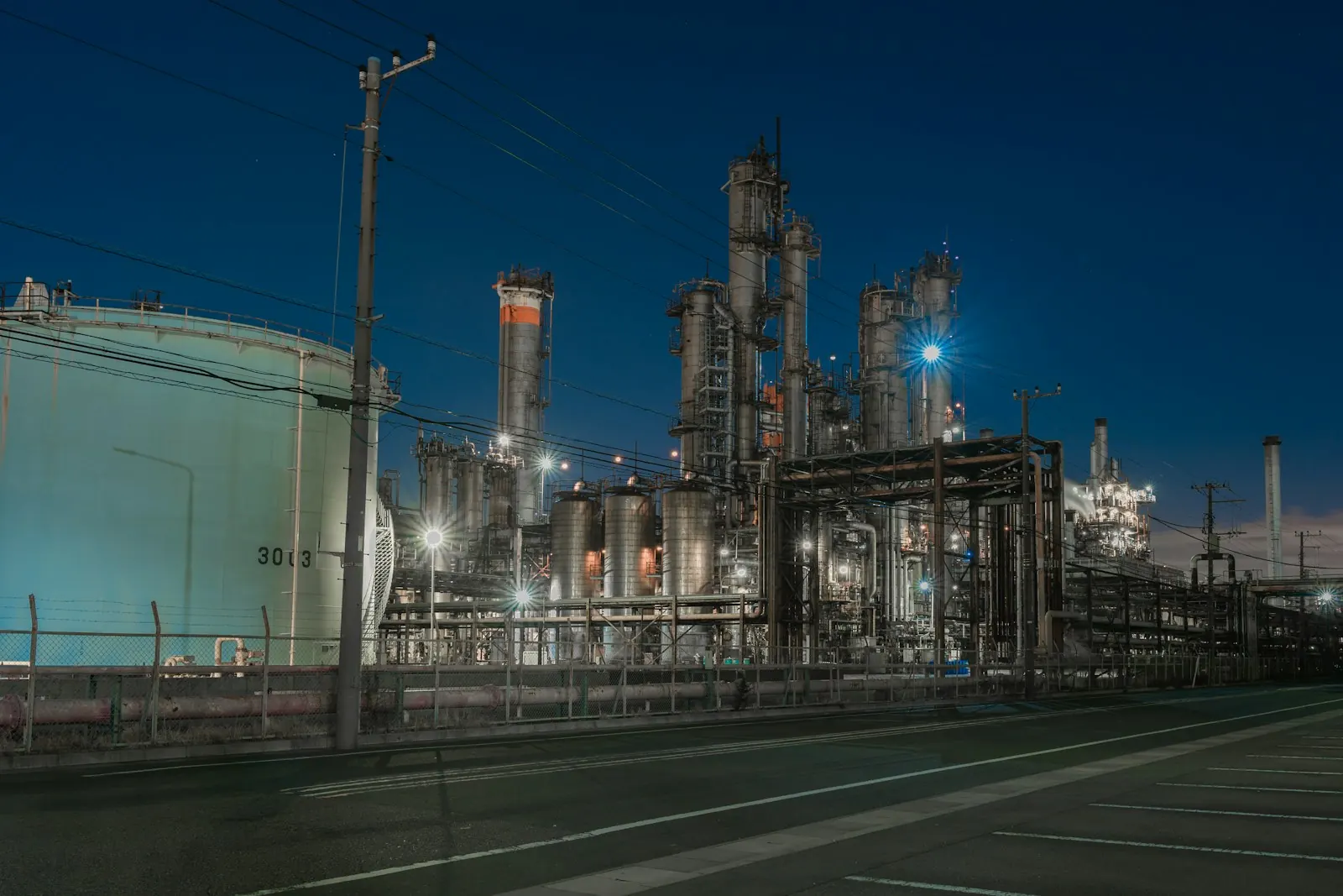 Process plant with towers, pipework and lights at night